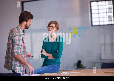 Le travail d'équipe fait le travail de rêve. Un groupe de jeunes créatifs qui parlent autour d'une table. Banque D'Images