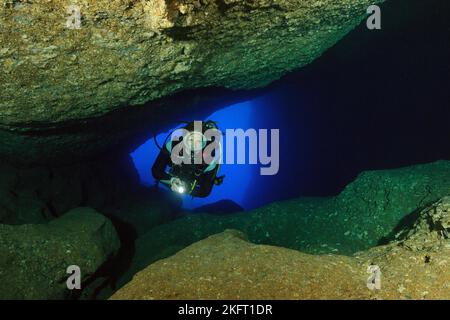 Diver sport Diver nage dans une grotte illuminée sous-marine, mer Méditerranée, Cala Ratjada, Majorque, Iles Baléares, Iles Baléares, Espagne, Euro Banque D'Images