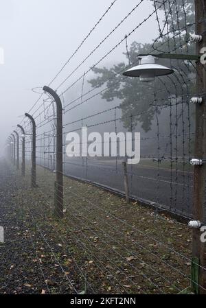 Une clôture de camp reconstruite avec un crématorium dans le brouillard au camp de concentration de la forêt de hêtres, aujourd'hui un mémorial de camp de concentration, Weimar, Thuringe, Allemagne Banque D'Images