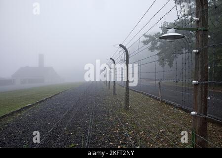 Une clôture de camp reconstruite avec un crématorium dans le brouillard au camp de concentration de la forêt de hêtres, aujourd'hui un mémorial de camp de concentration, Weimar, Thuringe, Allemagne Banque D'Images