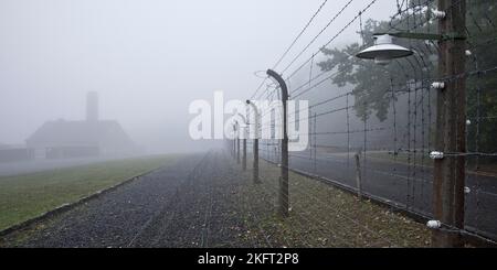Une clôture de camp reconstruite avec un crématorium dans le brouillard au camp de concentration de la forêt de hêtres, aujourd'hui un mémorial de camp de concentration, Weimar, Thuringe, Allemagne Banque D'Images