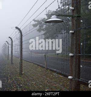 Une clôture de camp reconstruite avec un crématorium dans le brouillard au camp de concentration de la forêt de hêtres, aujourd'hui un mémorial de camp de concentration, Weimar, Thuringe, Allemagne Banque D'Images