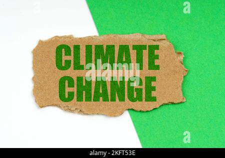 Concept environnemental. Sur un fond blanc-vert se trouve un morceau de carton avec l'inscription - changement climatique Banque D'Images