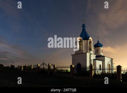 Église chrétienne blanche sur fond de ciel nocturne. Peut être utilisé comme arrière-plan, carte postale, peinture. Banque D'Images