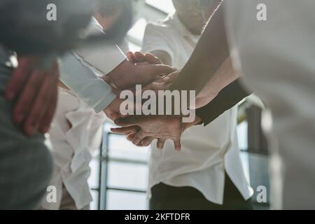 Regroupez les jeunes créatifs en vêtements élégants et décontractés en souriant et en croquant les bras sur un lieu de travail de bureau créatif. Banque D'Images