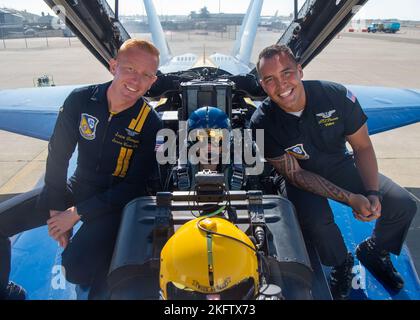 OAKLAND, Californie (oct 07, 2022) le compagnon d'électricien d'aviation de classe 2nd Sean Donoghue et le compagnon d'électricien d'aviation de classe 2nd Dale Pascua, affecté à l'escadron de démonstration de vol de la Marine, les Blue Angels, posent pour une photo avec Monica Barbaro, Top Gun: Maverick actrice. Les Blue Angels organisent des démonstrations de vol dans 32 endroits à travers le pays afin de présenter au public américain le travail d'équipe et le professionnalisme de la Marine et du corps des Marines des États-Unis. Banque D'Images