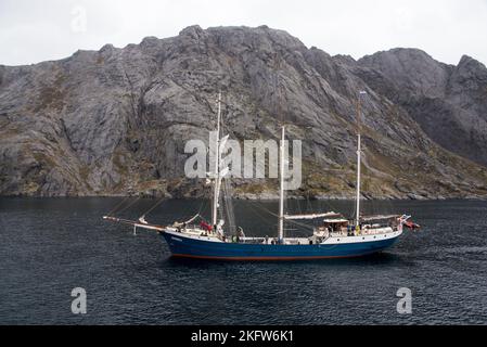 Barquentine Antigua entrant dans le port de Nusfjord qui est un petit village de pêcheurs pittoresque, mais très touristique sur l'archipel Lofoten de Norvège. Banque D'Images