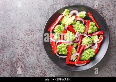 Concept de nourriture saine salade au chou romanesco, poivron et oignon rouge sur l'assiette de la table. Vue horizontale du dessus Banque D'Images