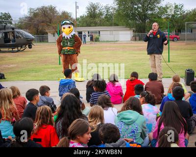 AUSTIN, Texas — Un agent spécial de la U.S. Drug Enforcement Administration parle avec des enfants à l'école élémentaire Glenmore le 11 octobre 2022, à San Angelo, Texas, avec le soutien du Texas National Guard joint CounterDrug Task Force qui a apporté un hélicoptère LUH-72 Lakota et leur mascotte, « Enney the Eagle », pour visiter l'école pendant les activités de la semaine du ruban rouge. Chaque année, le programme Texas CounterDrug soutient les activités de sensibilisation et de prévention du ruban rouge de DEA dans les écoles de l’État. Banque D'Images