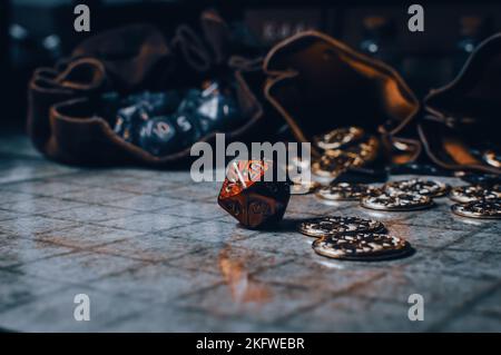 Le jeu de rôle rouge est joué sur une grille avec des pièces de monnaie et des sacs de dés Banque D'Images