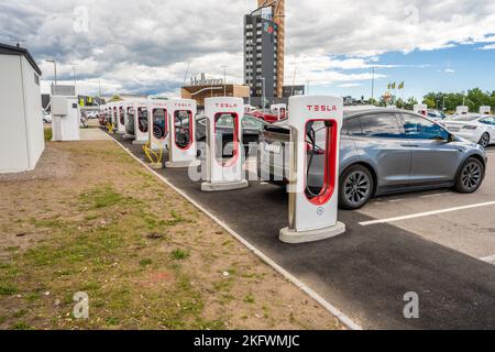 Halmstad, Suède - 10 juillet 2022: La longue rangée de voitures Tesla se charge au Supercharger de Tesla Halmstad Banque D'Images