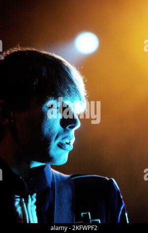 DÉBUT DU CONCERT, FRANZ FERDINAND, 2004 : un très jeune ALEXANDER KAPRANOS, chanteur et guitariste avec le groupe écossais FRANZ FERDINAND en tournée la semaine de sortie de leur premier album éponyme lors du NME Tour à Cardiff Students' Union, le 8 février 2004. Photographie : ROB WATKINS. INFO : Franz Ferdinand est un groupe de rock écossais formé en 2002, connu pour son son revival post-punk accrocheur et dansant. Leur premier album, 'Franz Ferdinand', et des tubes comme 'Take me Out' les ont catapultés à une renommée internationale et à une influence significative dans le rock indépendant. Banque D'Images