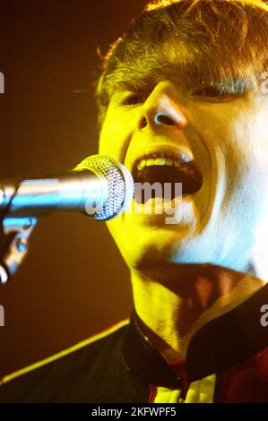 DÉBUT DU CONCERT, FRANZ FERDINAND, 2004 : un très jeune ALEXANDER KAPRANOS, chanteur et guitariste avec le groupe écossais FRANZ FERDINAND en tournée la semaine de sortie de leur premier album éponyme lors du NME Tour à Cardiff Students' Union, le 8 février 2004. Photographie : ROB WATKINS. INFO : Franz Ferdinand est un groupe de rock écossais formé en 2002, connu pour son son revival post-punk accrocheur et dansant. Leur premier album, 'Franz Ferdinand', et des tubes comme 'Take me Out' les ont catapultés à une renommée internationale et à une influence significative dans le rock indépendant. Banque D'Images