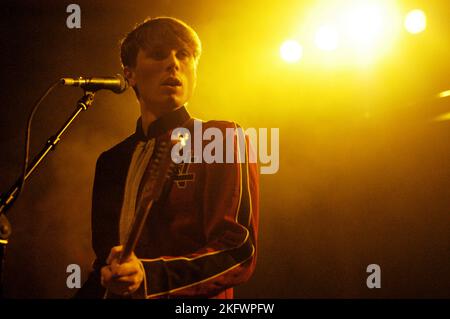 DÉBUT DU CONCERT, FRANZ FERDINAND, 2004 : un très jeune ALEXANDER KAPRANOS, chanteur et guitariste avec le groupe écossais FRANZ FERDINAND en tournée la semaine de sortie de leur premier album éponyme lors du NME Tour à Cardiff Students' Union, le 8 février 2004. Photographie : ROB WATKINS. INFO : Franz Ferdinand est un groupe de rock écossais formé en 2002, connu pour son son revival post-punk accrocheur et dansant. Leur premier album, 'Franz Ferdinand', et des tubes comme 'Take me Out' les ont catapultés à une renommée internationale et à une influence significative dans le rock indépendant. Banque D'Images