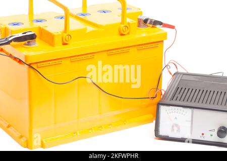 batterie de voiture jaune avec chargeur de batterie de voiture isolé sur fond blanc. Banque D'Images