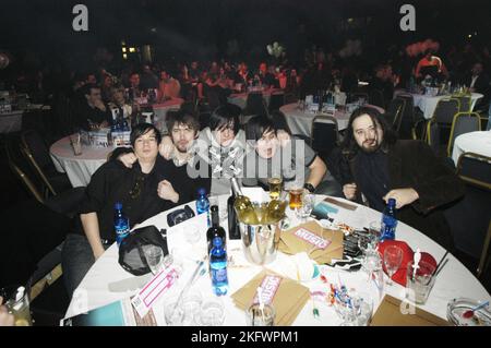 FUNÉRAILLES POUR Un AMI, CÉRÉMONIE DE REMISE DES PRIX, 2004 : funérailles pour Un ami autour de leur table pour une cérémonie de remise des prix en début de carrière Welsh Music Awards au Coal Exchange à Cardiff, le 20 février 2004. Photographie : ROB WATKINS. INFO : Funeral for a Friend est un groupe gallois de post-hardcore formé en 2001. Connus pour leur énergie intense et leurs paroles émotionnelles, ils gagnent en popularité avec des albums comme « Casually Dressed & Deep in conversation », avec des tubes comme « Juneau » et « Escape Artists Never Die ». Banque D'Images