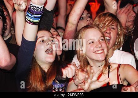 FANS DE ROCK, FUNERAL FOR A FRIEND, 2004 : FRONT ROW rock girls in the FOULE at FUNERAL FOR A FRIEND on the NME Tour at Cardiff Students' Union, 8 février 2004. Photographie : ROB WATKINS. INFO : Funeral for a Friend est un groupe gallois de post-hardcore formé en 2001. Connus pour leur énergie intense et leurs paroles émotionnelles, ils gagnent en popularité avec des albums comme « Casually Dressed & Deep in conversation », avec des tubes comme « Juneau » et « Escape Artists Never Die ». Banque D'Images