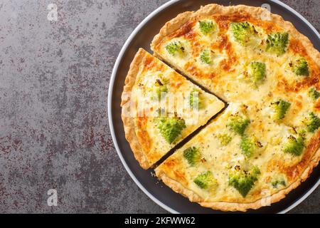 Quiche traditionnelle aux légumes avec brocoli romanesco et fromage en gros plan dans une assiette sur la table. Vue horizontale du dessus Banque D'Images