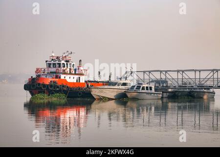 Des bateaux de patrouille de la marine indienne à une jetée près de Princep Ghat, Kolkata India, lors d'une matinée d'hiver brumeuse. Banque D'Images