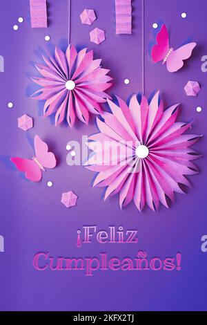 Feliz Cumpleanos signifie joyeux anniversaire en espagnol. Fans de papier, papillons et fleurs. Plat avec décorations printanières, décorations, boîte-cadeau Banque D'Images