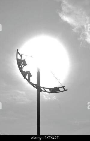 Photo verticale en niveaux de gris d'une lampe de rue contre le soleil Banque D'Images