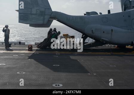 221013-N-XN177-2012 MER DES PHILIPPINES (OCT 13, 2022) – les Marines des États-Unis chargent de l'équipement sur un avion Tiltrotor MV-22 Osprey affecté à l'escadron Tiltrotor moyen marin (VMM) 262 (renforcé) sur le pont de vol à bord du porte-avions amphibie USS Tripoli (LHA 7) le 13 octobre 2022. Tripoli opère dans la zone d'opérations de la flotte américaine 7th afin d'améliorer l'interopérabilité avec ses alliés et ses partenaires et de servir de force de réaction prête à l'emploi pour défendre la paix et maintenir la stabilité dans la région Indo-Pacifique. Banque D'Images