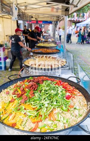 Une rangée de grands poêles à frire cuisinant divers aliments sur un marché en plein air pendant le festival alimentaire Sandwich le Weekend en Angleterre. Mise au point sélective. Banque D'Images