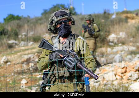 Salfit, Palestine. 20th novembre 2022. Les soldats israéliens gardent les colons juifs alors qu'ils saisissent les terres des agriculteurs palestiniens dans le village de Burqin, à l'ouest de Salfit, en Cisjordanie occupée. Les Palestiniens ont manifesté contre la confiscation de leurs terres par ces colons en faveur de la colonie juive de Brochin. Crédit : SOPA Images Limited/Alamy Live News Banque D'Images