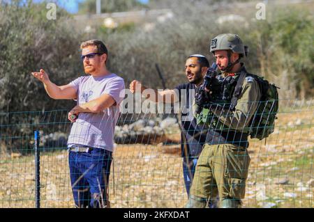 Salfit, Palestine. 20th novembre 2022. Les soldats israéliens gardent les colons juifs alors qu'ils saisissent les terres des agriculteurs palestiniens dans le village de Burqin, à l'ouest de Salfit, en Cisjordanie occupée. Les Palestiniens ont manifesté contre la confiscation de leurs terres par ces colons en faveur de la colonie juive de Brochin. Crédit : SOPA Images Limited/Alamy Live News Banque D'Images