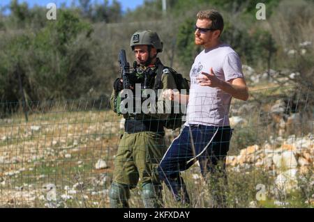 Salfit, Palestine. 20th novembre 2022. Les soldats israéliens gardent les colons juifs alors qu'ils saisissent les terres des agriculteurs palestiniens dans le village de Burqin, à l'ouest de Salfit, en Cisjordanie occupée. Les Palestiniens ont manifesté contre la confiscation de leurs terres par ces colons en faveur de la colonie juive de Brochin. Crédit : SOPA Images Limited/Alamy Live News Banque D'Images