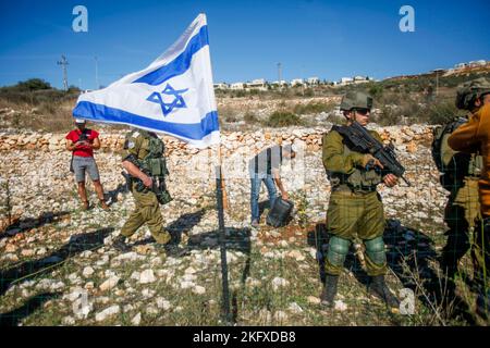 Salfit, Palestine. 20th novembre 2022. Les soldats israéliens gardent les colons juifs alors qu'ils saisissent les terres des agriculteurs palestiniens dans le village de Burqin, à l'ouest de Salfit, en Cisjordanie occupée. Les Palestiniens ont manifesté contre la confiscation de leurs terres par ces colons en faveur de la colonie juive de Brochin. Crédit : SOPA Images Limited/Alamy Live News Banque D'Images