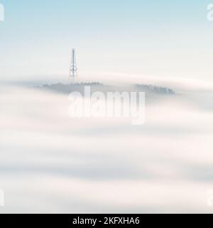 Le mât radio au sommet de Norwood Edge est visible au-dessus d'une mer de brouillard qui roule lors d'une inversion de température d'automne dans la vallée de Washburn. Banque D'Images