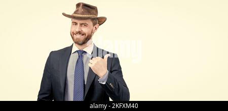 Regardez ceci. Publicité de l'homme de point de doigt de côté. Expert en publicité dans chapeau de cow-boy. Portrait de visage d'homme, bannière avec espace de copie. Homme d'affaires en costume Banque D'Images
