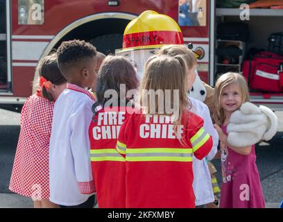 Les enfants du Centre pour le développement de l'enfant reçoivent un câlin de Sparky le chien d'incendie, la mascotte officielle de la National Fire protection Association pendant la tournée de la semaine de prévention des incendies à la CDC sur la base aérienne de Keesler, Mississippi, le 13 octobre 2022. Tout au long de la semaine, le Service des incendies de Keesler a mené des exercices d'incendie aléatoires, visité diverses installations avec Sparky le chien d'incendie, transmis des renseignements sur la sécurité incendie et des chapeaux d'incendie pour les enfants. Banque D'Images