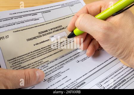 Un homme remplit une déclaration de revenus annuelle à l'office fiscal de Pologne, Pit 37 formulaire, règlement pour les particuliers Banque D'Images