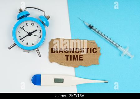 Concept médical. Une horloge, un thermomètre, une seringue et un carton avec l'inscription - heure de diagnostic Banque D'Images