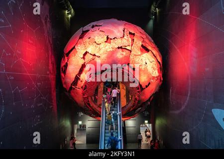 Les visiteurs emportant un escalier mécanique au Earth Hall à travers un globe rouge au Musée d'Histoire naturelle de Londres Banque D'Images