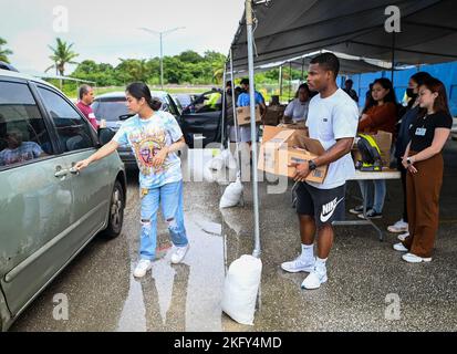 Des aviateurs de l'escadron des munitions 36th font du bénévolat au cours d'une ligne de distribution de nourriture au Yigo Gymnasium à Yigo, Guam, le 14 octobre 2022. Les bénévoles ont été obtenus par l’entremise du programme de l’escadron de consœur du village de consœurs d’équipe Andersen. Les aviateurs MUNS ont aidé leur village jumeau à distribuer des milliers de livres de nourriture aux résidents de Yigo et à ceux qui en ont besoin. Banque D'Images