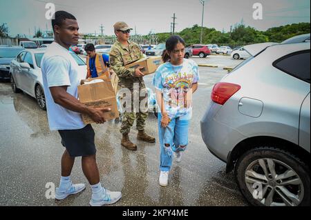 Des aviateurs de l'escadron des munitions 36th font du bénévolat au cours d'une ligne de distribution de nourriture au Yigo Gymnasium à Yigo, Guam, le 14 octobre 2022. Les bénévoles ont été obtenus par l’entremise du programme de l’escadron de consœur du village de consœurs d’équipe Andersen. Les aviateurs MUNS ont aidé leur village jumeau à distribuer des milliers de livres de nourriture aux résidents de Yigo et à ceux qui en ont besoin. Banque D'Images