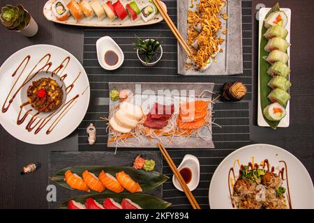 Ensemble de plats japonais avec beaucoup de sashimi, rouleaux de riz et de poisson et nigiris. Sauce soja et baguettes en bois Banque D'Images