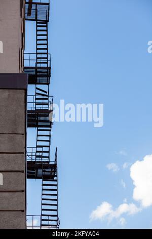 Silhouette d'une évasion au feu sur un bâtiment haut contre un ciel bleu Banque D'Images