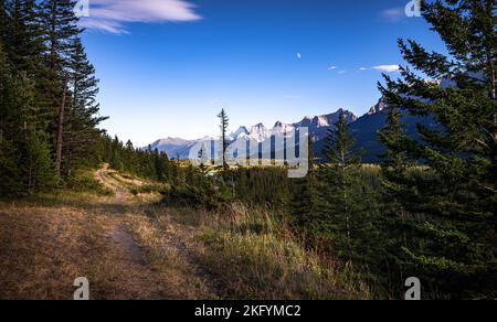 Paysage des montagnes Rocheuses avec route et champs en premier plan au crépuscule dans le parc national Banff, Canada. Banque D'Images