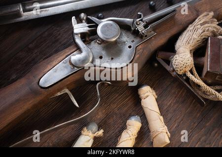 ancienne mousquet de flintlock du xviie siècle avec ballon de poudre et balles led sur terrasse en bois. Banque D'Images