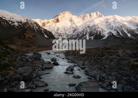 La rivière Hooker mène au lac Mueller et avec le mont Sefton au-dessus de la lumière du soleil levant du matin. Banque D'Images