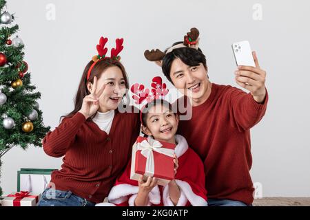 Bonne famille asiatique coréenne à Noël concept prendre un selfie Banque D'Images