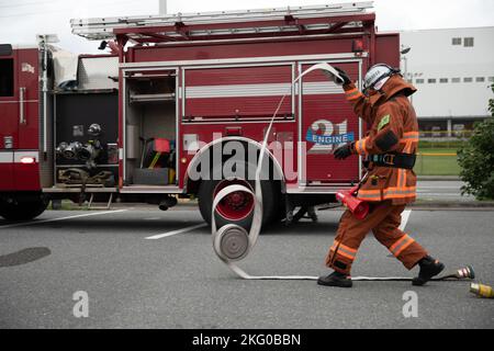 Un pompier avec le service d'incendie d'Urasoe délite un tuyau d'incendie pendant un scénario d'entraînement à Camp Kinser, Okinawa, Japon, 18 octobre 2022. La caserne de pompiers de Camp Kinser et le service des incendies d'Urasoe ont mené une formation bilatérale pendant l'exercice constant vigilance afin de renforcer leur capacité à répondre conjointement aux crises. Banque D'Images