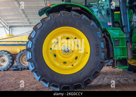 Une grande roue et un pneu de tracteur à l'arrière, dans un grand hangar ouvert ou une grange sur une ferme dans le nord-ouest de la Nouvelle-Galles du Sud, en Australie Banque D'Images