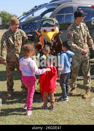 AUSTIN, Texas — Un agent spécial de la U.S. Drug Enforcement Administration parle avec des enfants à la Cottonwood Creek Elementary School 18 octobre 2022, à Hutto, Texas, avec le soutien du Texas National Guard joint CounterDrug Task Force qui a apporté un hélicoptère LUH-72 Lakota et leur mascotte, « Enney the Eagle », pour visiter l'école pendant les activités de la semaine du ruban rouge. Chaque année, le programme Texas CounterDrug soutient les activités de sensibilisation et de prévention du ruban rouge de DEA dans les écoles de l’État. Banque D'Images