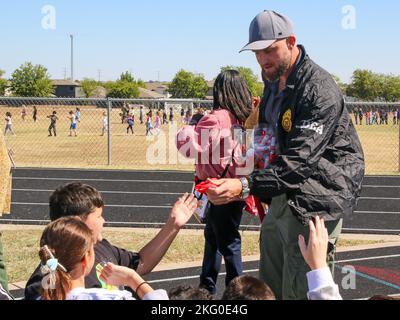 AUSTIN, Texas — Un agent spécial de la U.S. Drug Enforcement Administration parle avec des enfants à la Cottonwood Creek Elementary School 18 octobre 2022, à Hutto, Texas, avec le soutien du Texas National Guard joint CounterDrug Task Force qui a apporté un hélicoptère LUH-72 Lakota et leur mascotte, « Enney the Eagle », pour visiter l'école pendant les activités de la semaine du ruban rouge. Chaque année, le programme Texas CounterDrug soutient les activités de sensibilisation et de prévention du ruban rouge de DEA dans les écoles de l’État. Banque D'Images