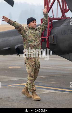 Les soldats affectés à la Delta Company, 1-229 Bataillon d'attaque, 16th Brigade de l'aviation de combat, se préparent à charger un hélicoptère d'attaque Apache AH-64E à l'aérodrome de l'Armée Grey, Washington, le 20 octobre 2022. Les soldats s'étaient formés avec des aviateurs à bord de l'hélicoptère Apache C-17 AH-64E pour les procédures de chargement et de déchargement. Banque D'Images